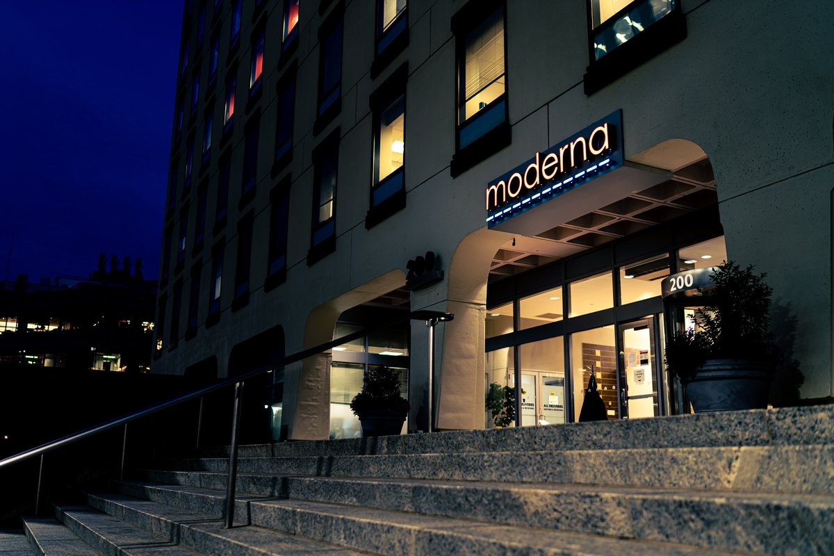 A lighted sign displays the moderna logo above the main entrance to global headquarters for Moderna Therapeutics in Cambridge, Massachusetts.